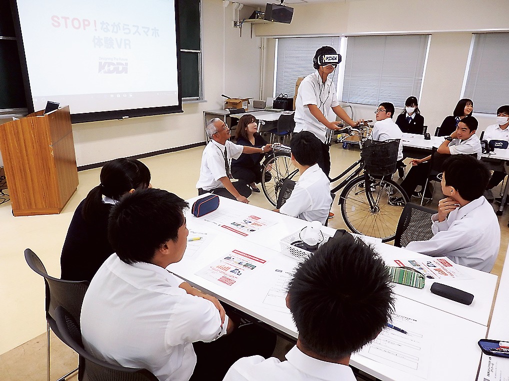 実際に自転車に乗りながらVRキットを装着する生徒