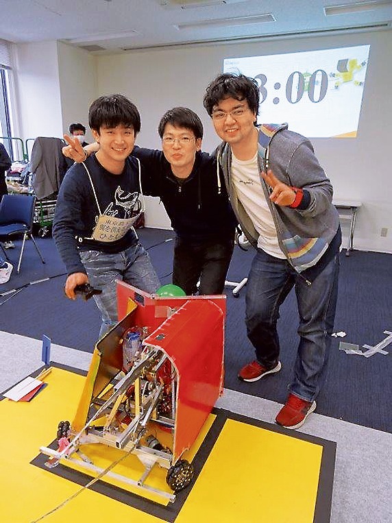 第12回ロボットコンテストで優勝した東京農工大学 翼を供える専念寺チームメンバー（右から久保さん、櫛野さん、布村さん）とロボット「ひとしくん」