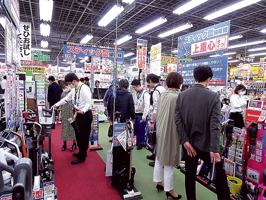 スティック型掃除機売り場で商品を試す来店客（ともにヨドバシAkiba）