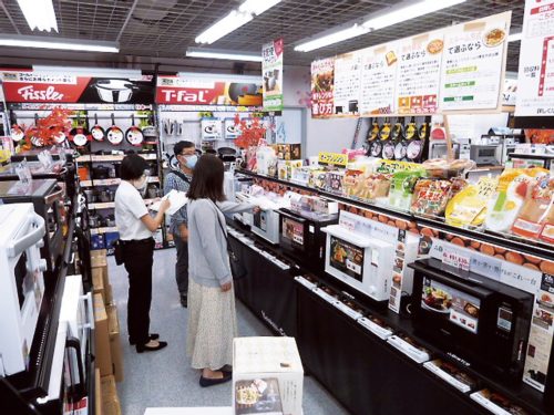 量販店店頭で調理家電を品定めする来店者