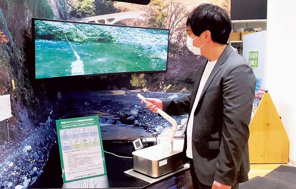 渓流に設置された「テレアングラー」を遠隔地から操作し、魚を釣り上げている