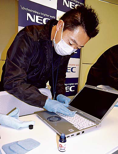 ガラスコーティング剤「Dr．ハドラスEX」を塗布する作業者＝東京都港区のNEC本社