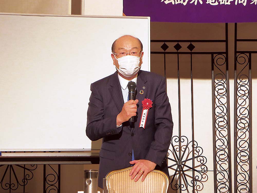 記念講演で祝辞を述べる峯田会長