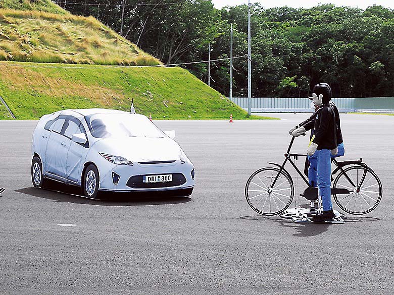 デモ試験を行ったダミー車（左）と模擬歩行者