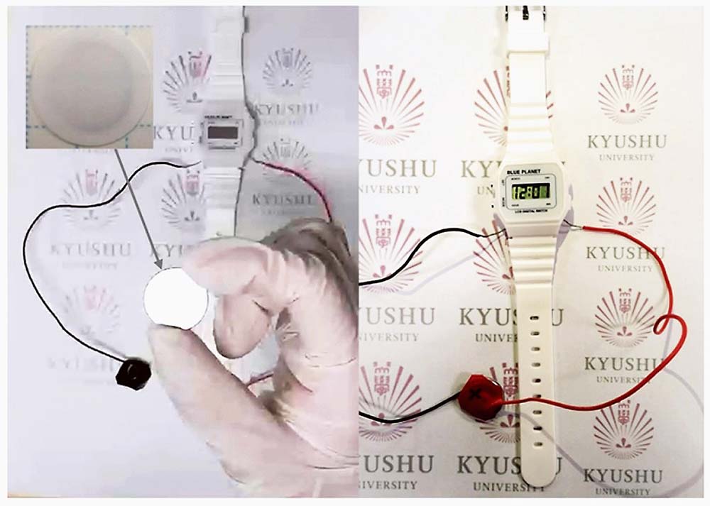 今回の研究成果によるデジタル時計の駆動。作成されたコイン型電池の内部で使用されている電極は実際には1マイクロメートル前後の厚みで、磁器表面の絵付け程度に相当する微量だが、デジタル時計を駆動させている。左上はセラミック電解質上に形成されたガラス・セラミック電極活物質