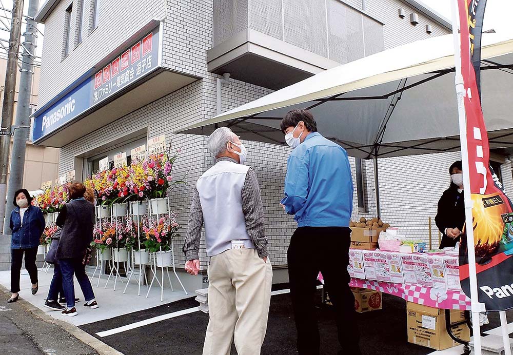 開店早々、お客が来店。対応する高橋店長（中央右）