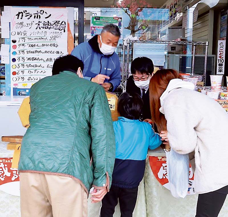 何等が出るか、興味津々にのぞき込む家族連れ