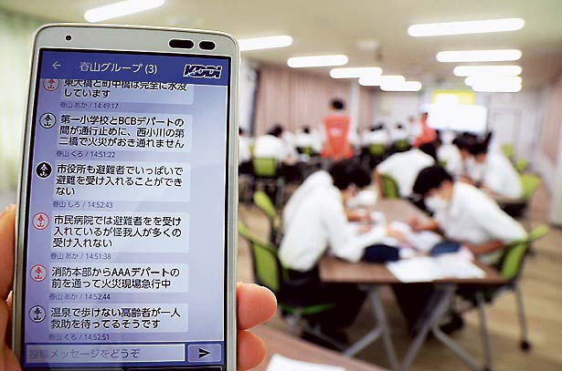 スマホで他班の生徒と情報交換しながら、避難場所やルート、救助場所を模索する