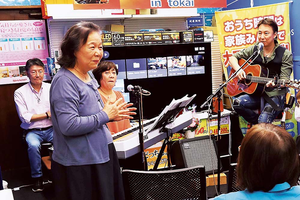 来場者の前でOKAJIさんとJUNKOさんを紹介する鈴木店長