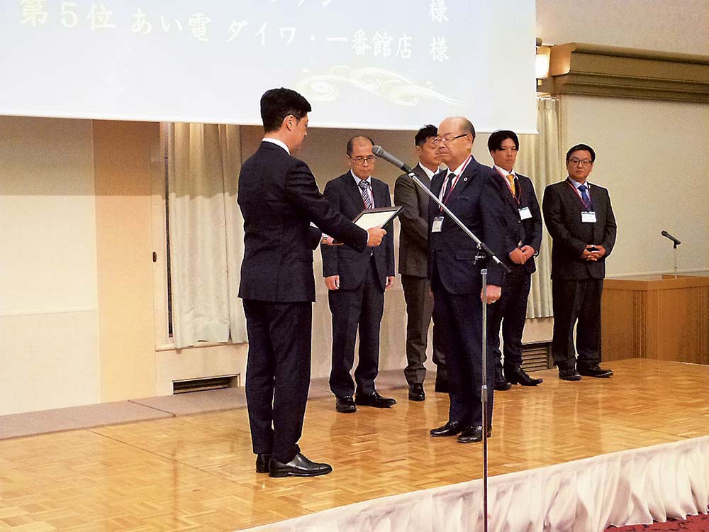 小本副社長から賞状などを受ける峯田会長（前列右）