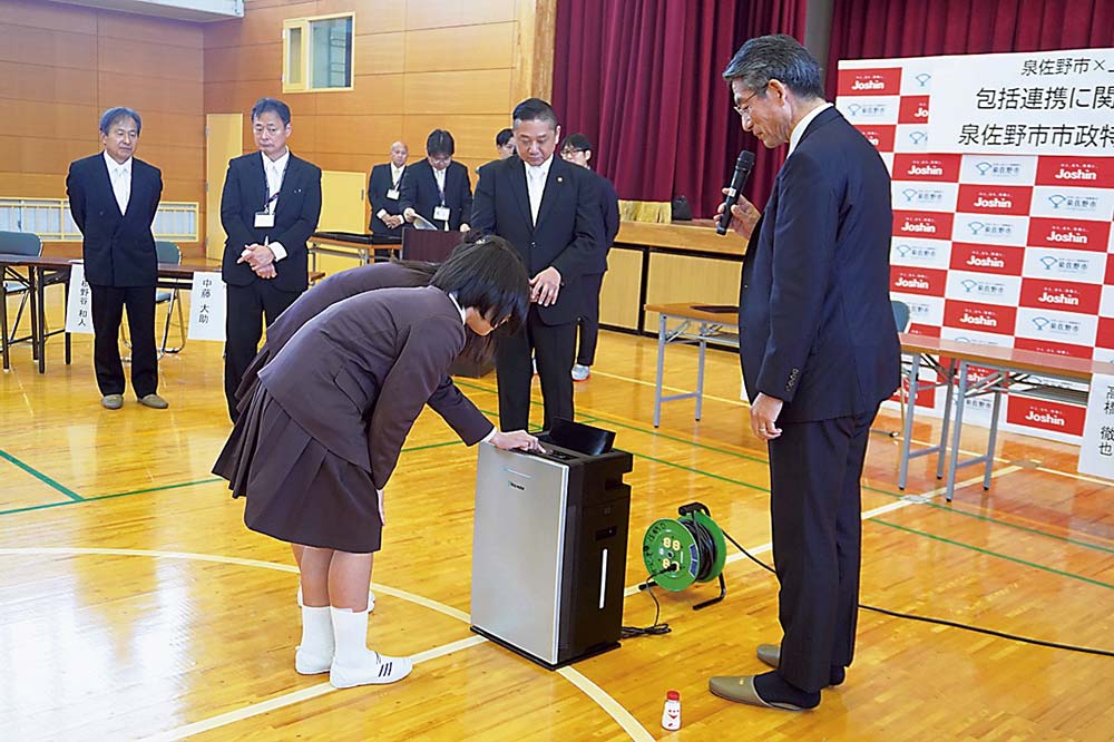 高橋副社長から説明を受け空気清浄機を操作する児童