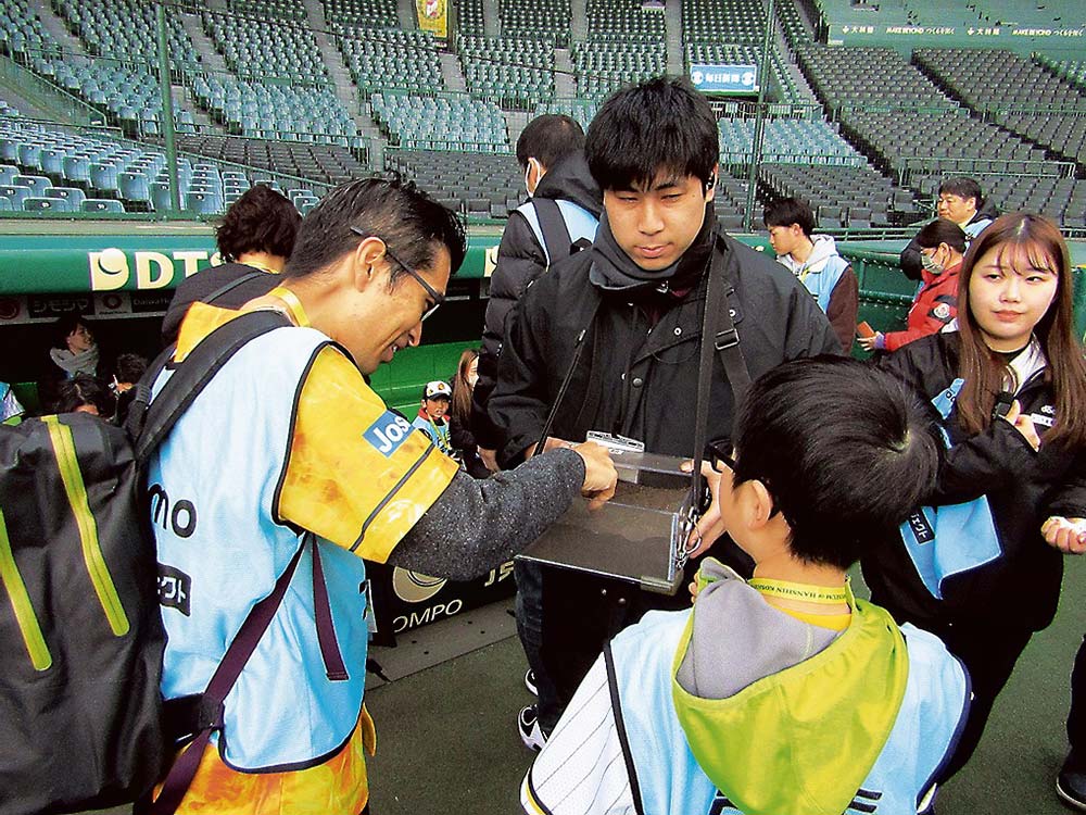 甲子園の砂を触る参加者