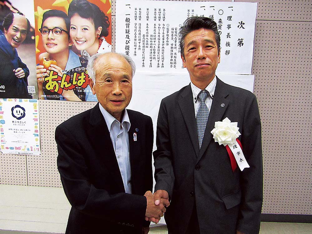 𠮷田前理事長（左）と敷地新理事長