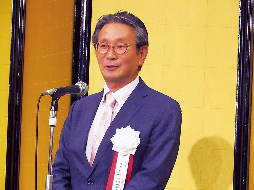 あいさつする竹間新支部長