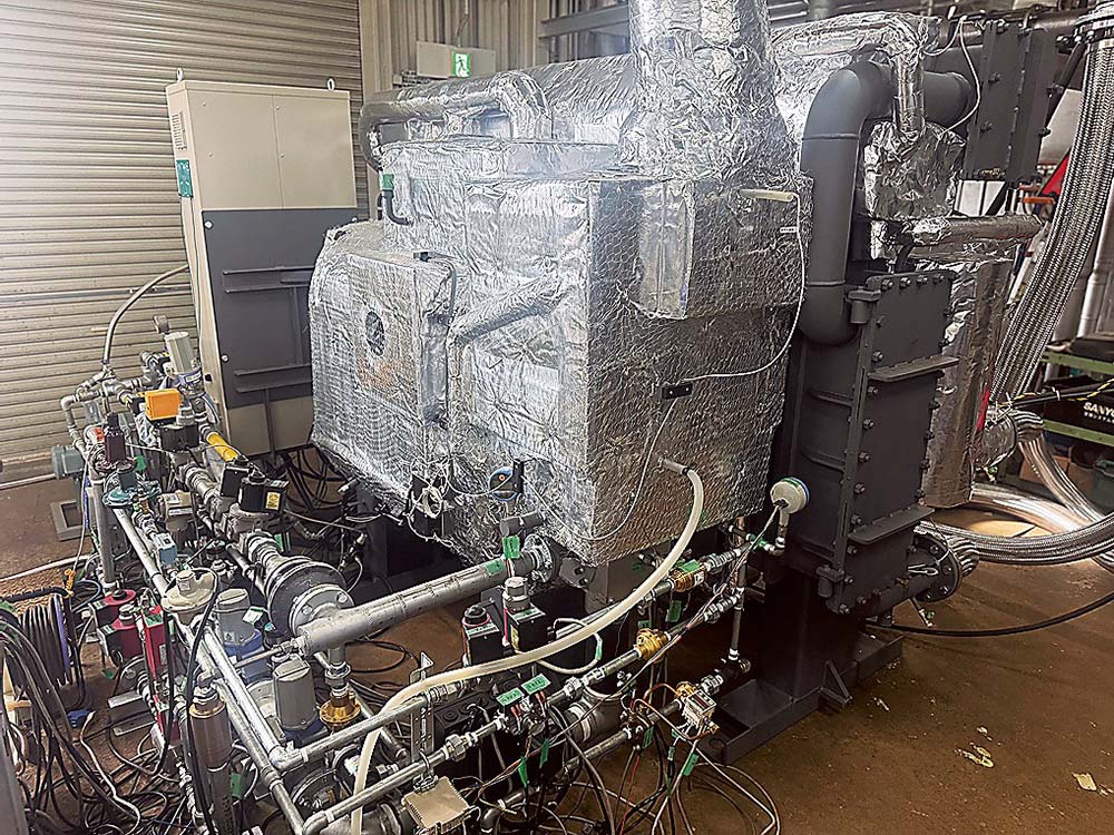 水素と都市ガス混焼対応の吸収式冷温水機実証機（手前の配管が入り組んだ部分が水素／都市ガス専焼・混焼燃料制御ユニット）