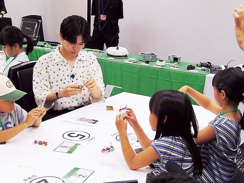 参加者とコイルモーターづくりを楽しむ鈴木さん