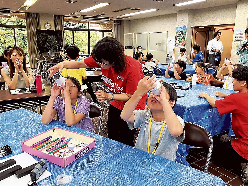 光万華鏡をのぞく子どもたち