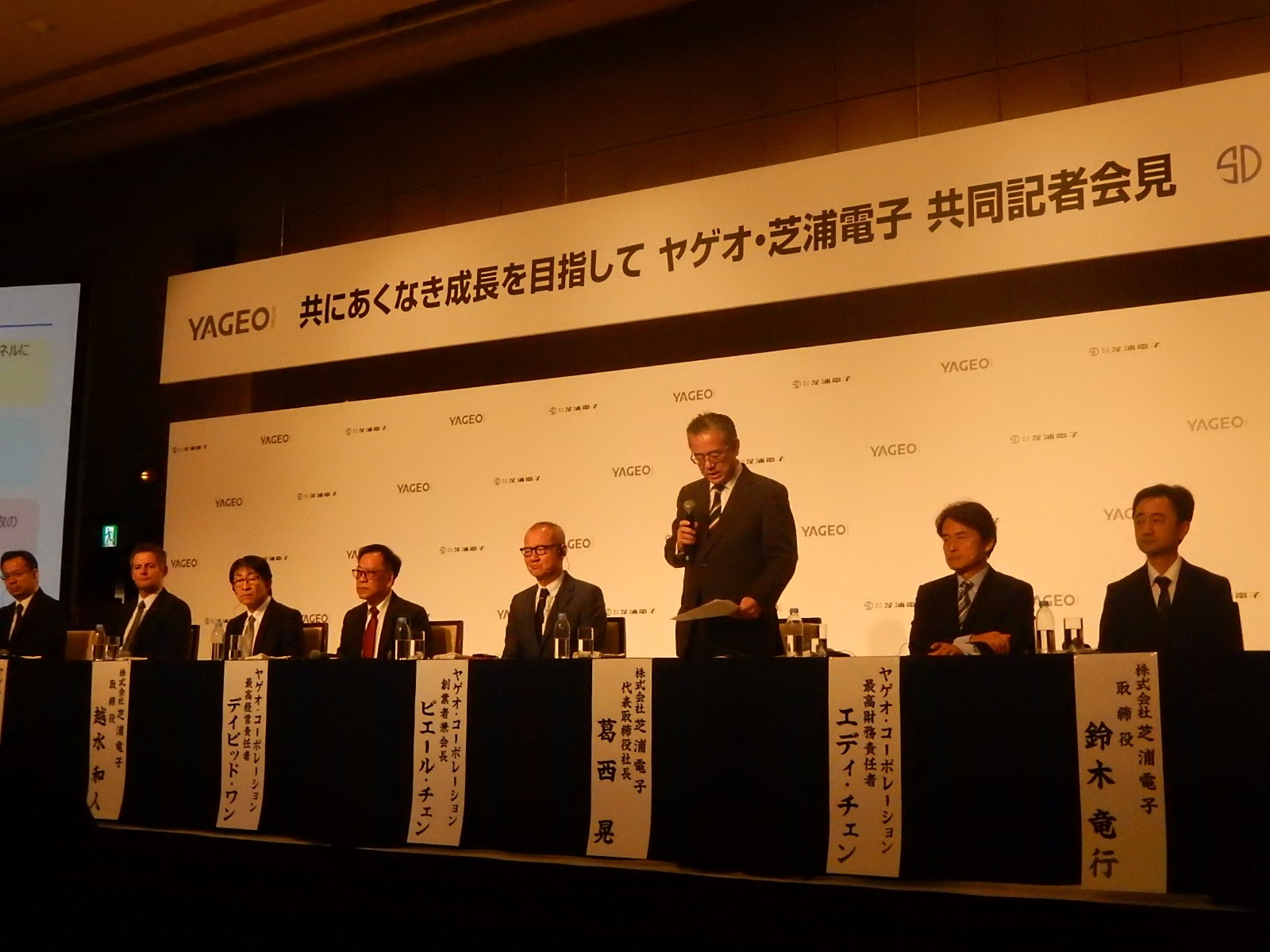 共同記者会見には、両社合わせて計８人の役員が出席した 