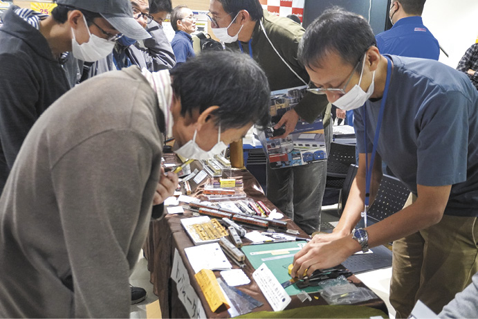 鉄道模型ショーでメーカー担当者の実演を熱心に見つめる参加者