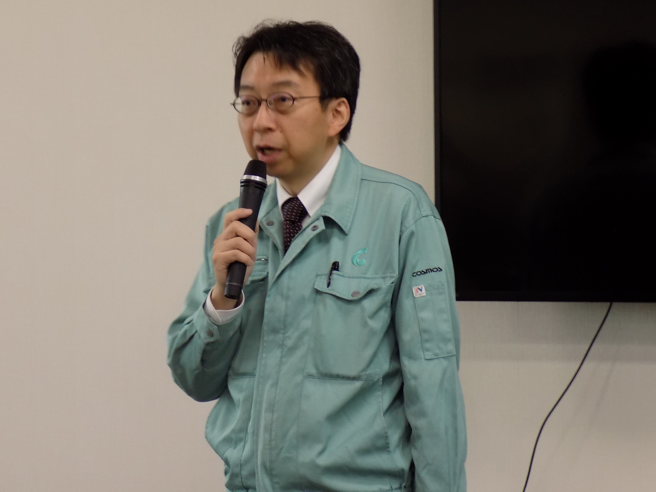 あいさつする新コスモス電機の山田取締役