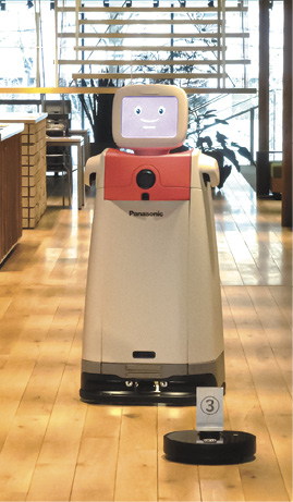 小型清掃ロボットが停止し、搬送ロボットがすれ違うのを待っている