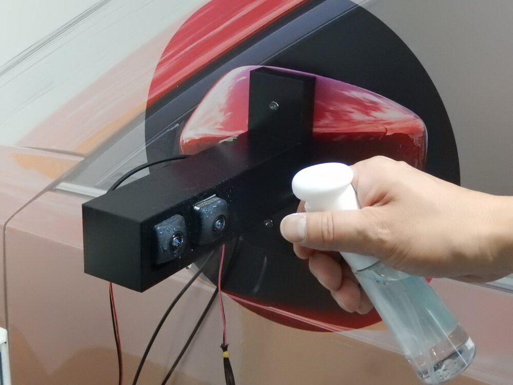 村田製作所が開発中の「超音波式雨滴除去デバイス」によるデモの様子