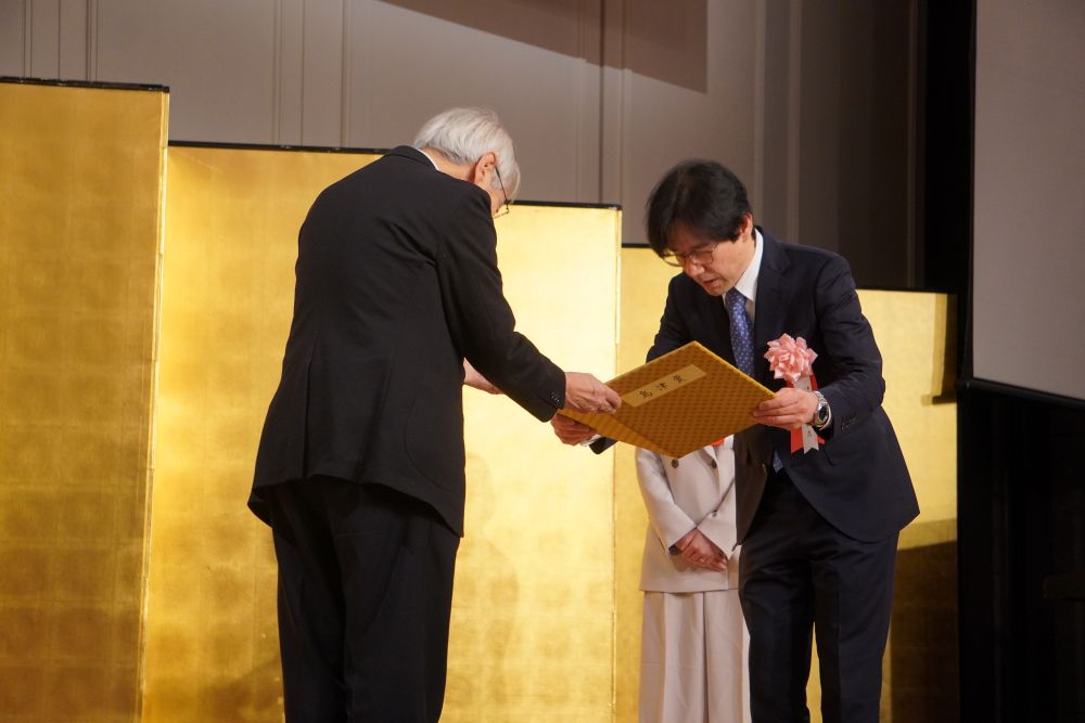 賞状を受け取る胡桃坂教授(右)