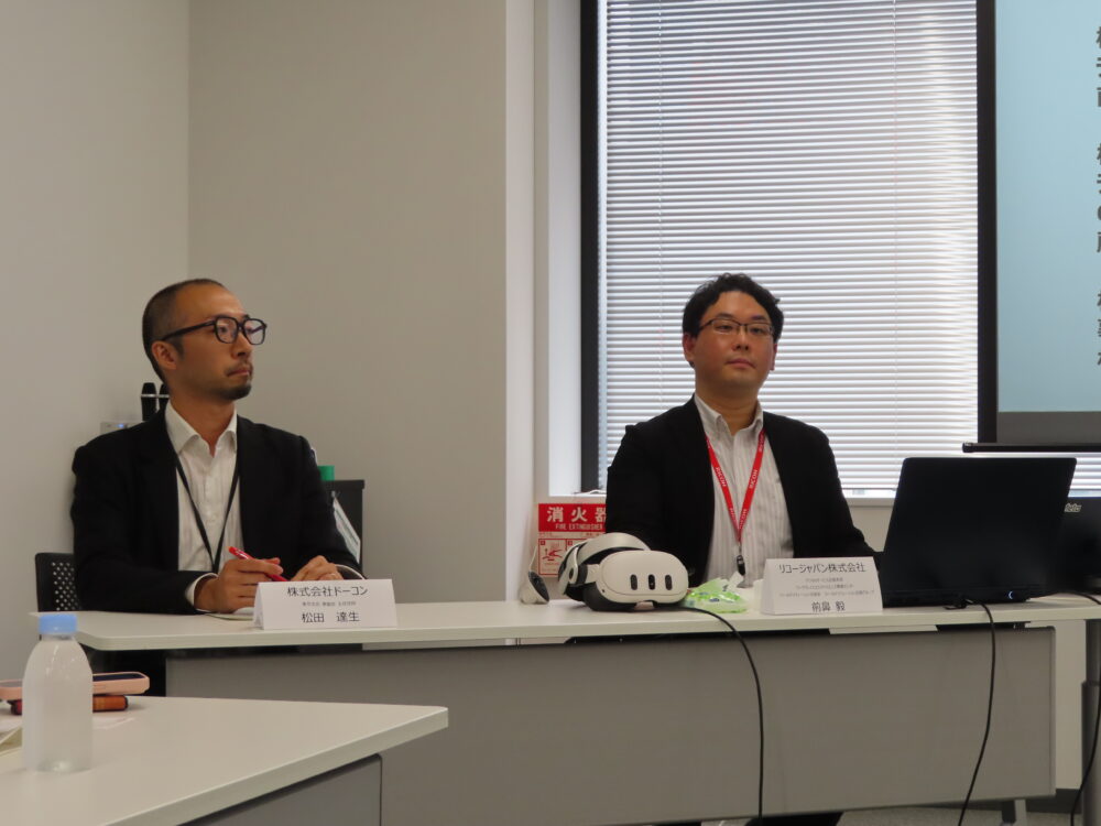 会見するリコージャパンの前鼻氏(右)とドーコン東京支店の松田達生主任技師