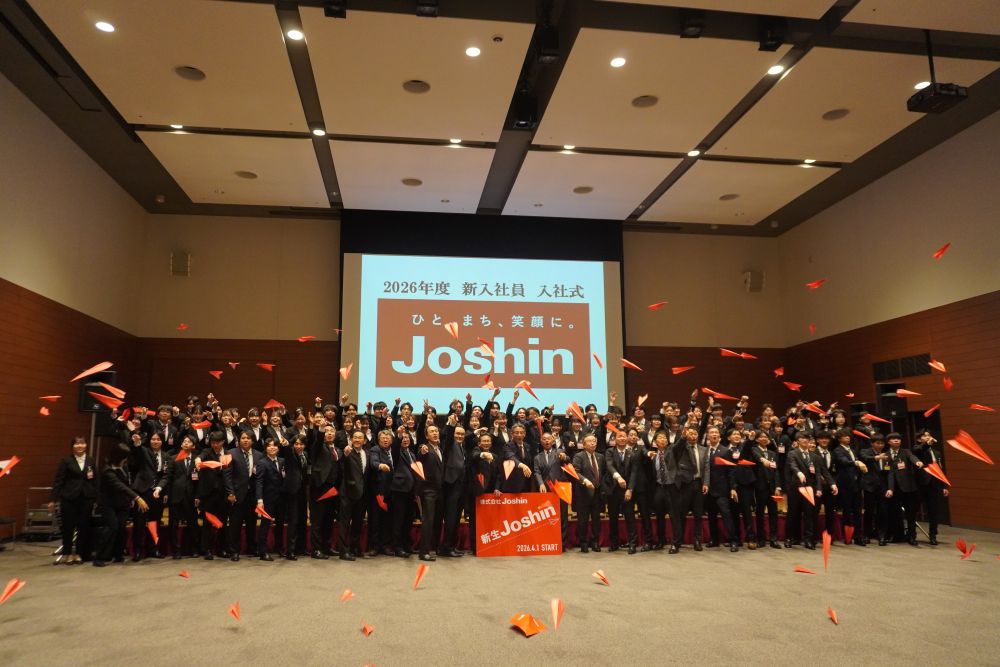 新入社員と役員が一斉に赤い紙飛行機を飛ばし飛躍を誓った