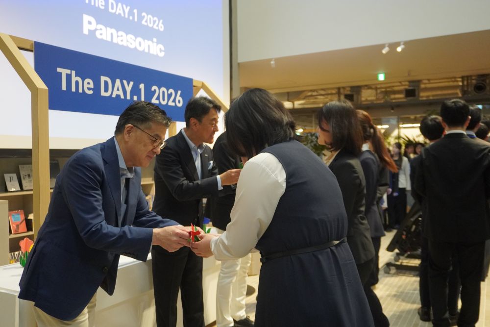 楠見グループCEOらが新入社員にペーパークラフトを手渡した 