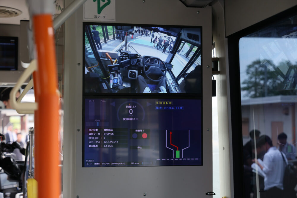 車両内に設置された運転システムの状態（下）と運転席を映すモニター＝28日午前、宮城県登米市