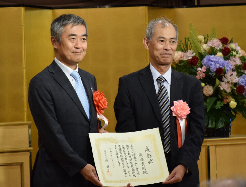 情報通信技術賞・総務大臣表彰は、NTTアドバンステクノロジの後藤氏（右）に贈られた