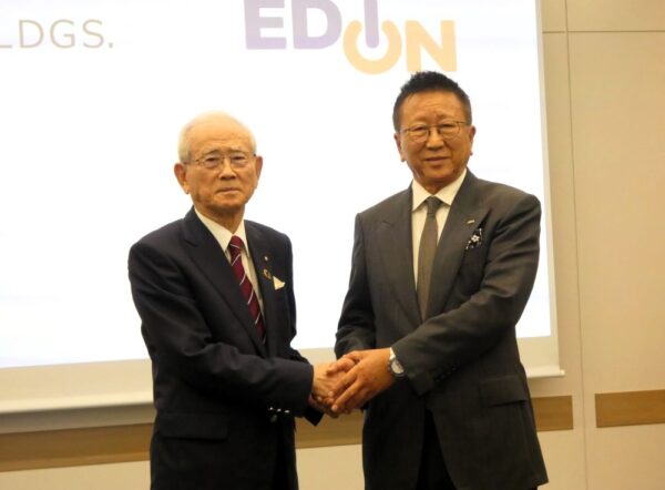 5日の会見で握手するヤマダHDの山田会長兼CEO（左）とエディオンの久保允誉会長執行役員CEO