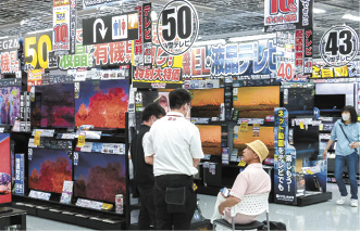 テレビ売り場で説明を受ける買い物客
