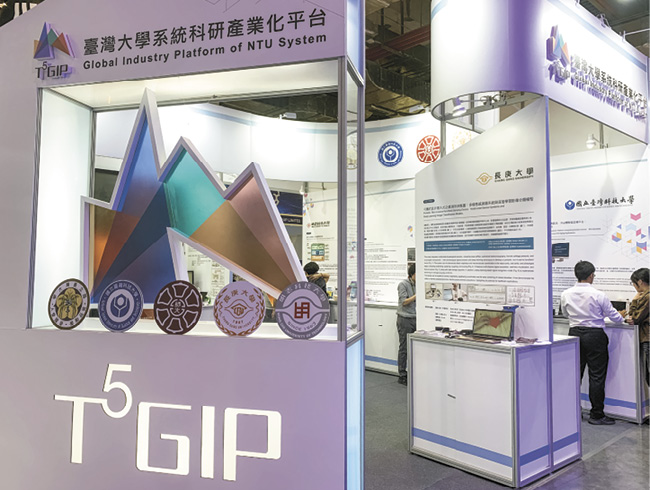 スタートアップ展示会「InnoVEX」に出展した産学連携プラットフォーム「T5GIP」のブース。5大学の校章が並ぶ