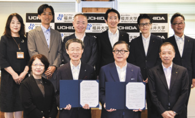包括連携協定書を手にする福井大学の内木学長（前列中央左）と内田洋行の大久保社長（同右）ら関係者